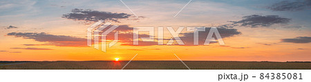 Landscape Of Wheat Field Under Scenic Summer Dramatic Sky In Sunset Dawn Sunrise. Skyline. Panorama, Panoramic View 84385081