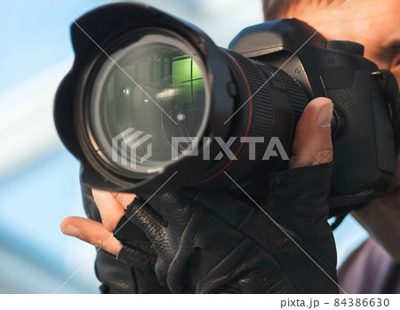 professional photographer taking a picture on the camera. professional photographer taking a picture on the camera. 84386630