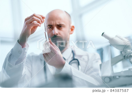 background image of a researcher examining samples of a new vaccine. 84387587