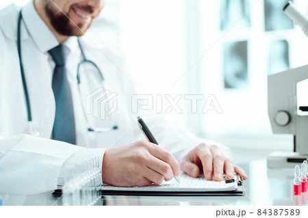 researcher writes down the results of research in a laboratory journal. 84387589