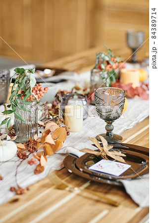 Long wooden table with kitchenware and decorations 84389714