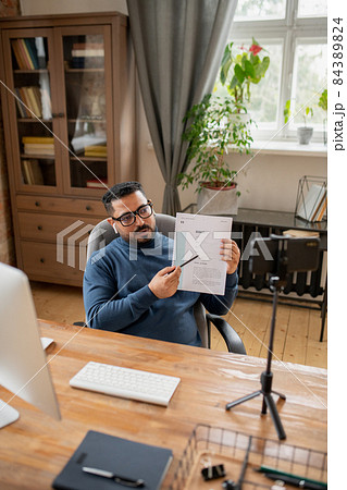 Contemporary teacher pointing at financial paper during training 84389824