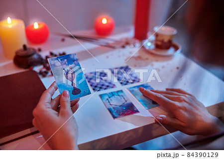 Experienced fortune-teller reading cards laid out on the divination table 84390129