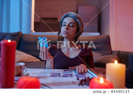 Dark-haired Caucasian soothsayer focused on her divination Dark-haired Caucasian soothsayer focused on her divination 84390135