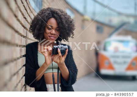 Pretty young female photographer checking photos Pretty young female photographer checking photos 84390557