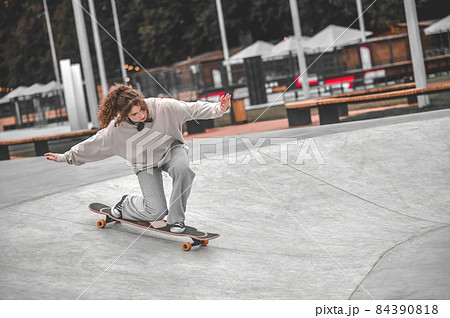 Girl on skateboard on bent legs rolling down 84390818