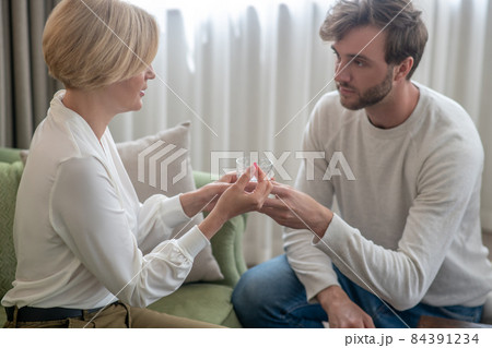 Son giving his mother a glass of water while she feeling unwell Son giving his mother a glass of water while she feeling unwell 84391234