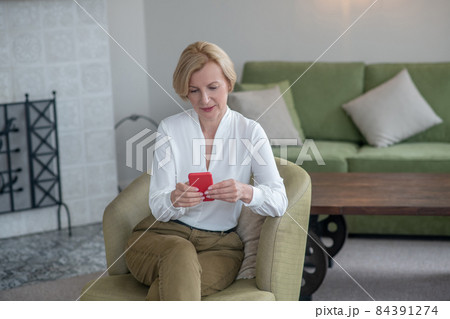 Blonde woman with a smartphone in hands Blonde woman with a smartphone in hands 84391274