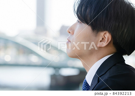 空を見つめるスーツ姿の男性 84392213