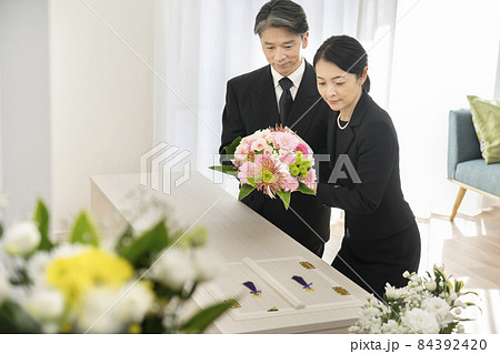棺に花束を供えるミドルの男女　家族葬　自宅葬イメージ 84392420