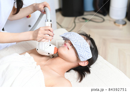 サロンの機械で脱毛の施術をするスタッフと女性のお客 サロンの機械で脱毛の施術をするスタッフと女性のお客 84392751