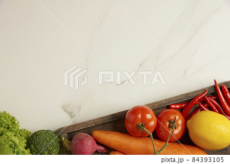 vegetable concept many types of green, red, orange and yellow vegetables being prepared on the white tile table vegetable concept many types of green, red, orange and yellow vegetables being prepared on the white tile table 84393105
