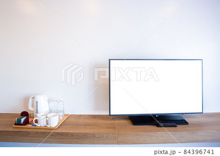 Monitor led television or TV with empty white screen and Coffee maker set aluminum electric kettle,clean white cup,white sugar on brick wall interior room in hotel 84396741