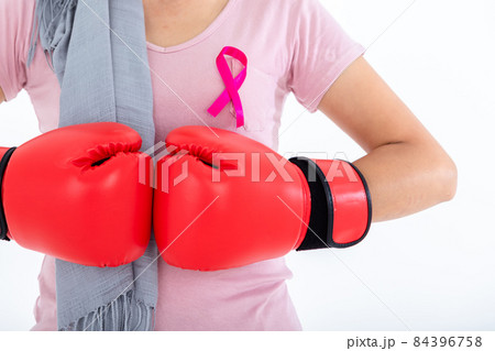 Close up of a asian woman disease mammary cancer patient fighting showing boxing gloves breast cancer awareness month isolated on white blank copy space studio background,healthcare,medicine concept 84396758