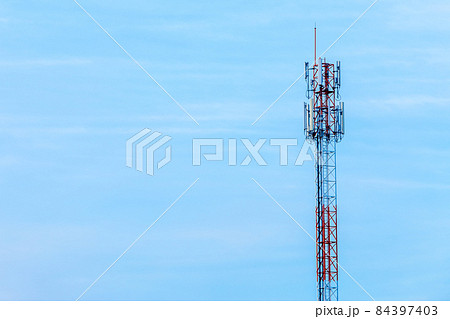 Mobile station receiver antenna tower with fluffy clouds blue sky daylight background. Mobile station receiver antenna tower with fluffy clouds blue sky daylight background. 84397403