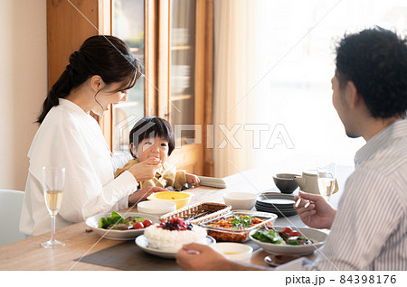 ご飯を食べさせる美人なママさんと赤ちゃん 84398176