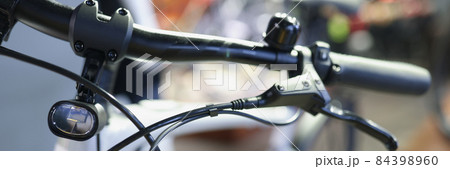 Bicycle handlebars with handbrake and flashlight closeup 84398960