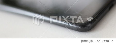 Smartphone with broken front screen is lying on table closeup 84399017