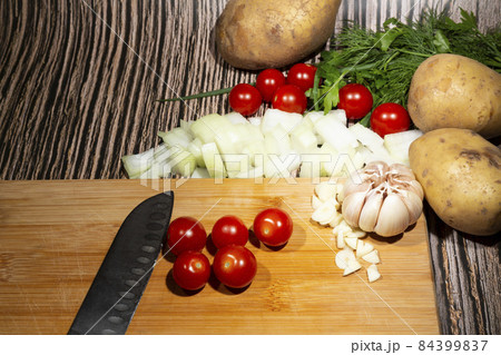Cherry tomatoes on a wooden board next to vegetables. The concept of proper nutrition. Vegetarianism. 84399837