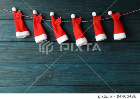 Twine with Santa Claus hats with red houses on wooden background 84400436