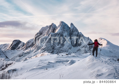 Mountaineer standing on Segla mountain with majestic snowy mount on winter at Senja island 84400864