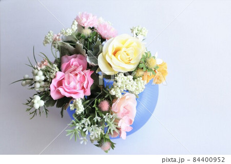 青いガラスの花瓶に生けられた造花の花束 青いガラスの花瓶に生けられた造花の花束 84400952