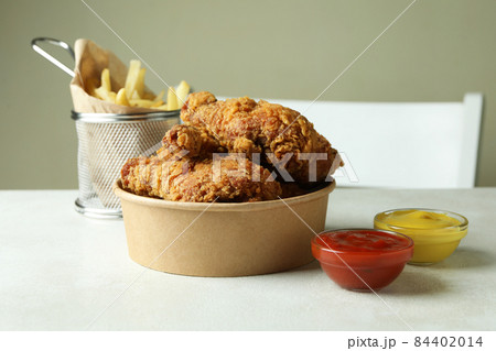 Concept of tasty eating with fried chicken on white textured table 84402014