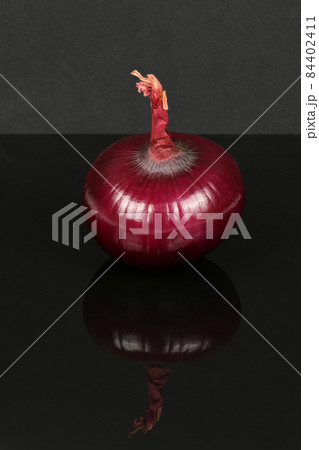 Red onion bulb isolated on acrylic black background. Red onion bulb isolated on acrylic black background. 84402411