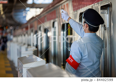 電車の発車前の確認をする赤い腕章をした見習い車掌 電車の発車前の確認をする赤い腕章をした見習い車掌 84402599
