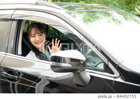車の中から手を振る美人な日本人女性 カメラ目線	 84402755