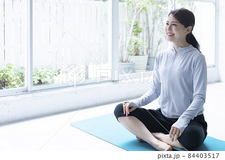 瞑想やストレッチでリラックスする笑顔の若い女性 瞑想やストレッチでリラックスする笑顔の若い女性 84403517