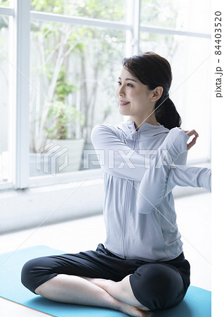 窓辺でストレッチをする若い女性 窓辺でストレッチをする若い女性 84403520