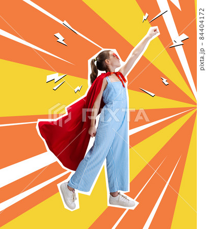 Contemporary art collage, creative design of little girl wearing red cloak and standing like superhero isolated over orange yellow background 84404172
