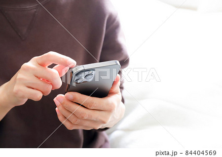 スマホを操作する手元 84404569