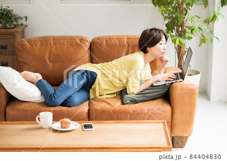 ソファーにうつ伏せでパソコンを操作する女性 ソファーにうつ伏せでパソコンを操作する女性 84404830