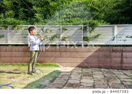 芝生に水やりをする小学生の男の子 芝生に水やりをする小学生の男の子 84407383