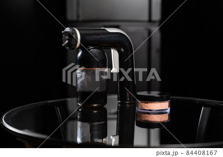 A close-up of the instant tanning equipment. Gun spraying paint for leather and matting body powder on a black background A close-up of the instant tanning equipment. Gun spraying paint for leather and matting body powder on a black background 84408167