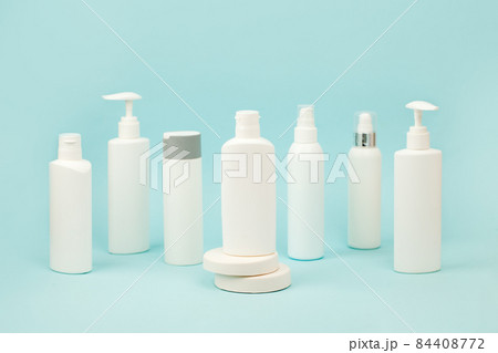 Set of white cosmetic bottles with soft shadows on light blue background. Home and beauty salon care concept, mock up, copy space, beauty industry banner, flyer, coupon, selective focus Set of white cosmetic bottles with soft shadows on light blue background. Home and beauty salon care concept, mock up, copy space, beauty industry banner, flyer, coupon, selective focus 84408772