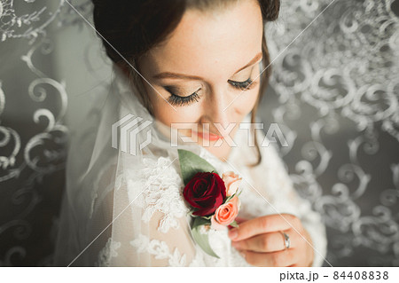 Beautiful bride wearing fashion wedding dress with feathers with luxury delight make-up and hairstyle, studio indoor photo shoot 84408838