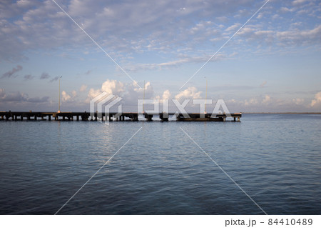The morning seascape. The pier, the sea and soft clouds above it. The morning seascape. The pier, the sea and soft clouds above it. 84410489