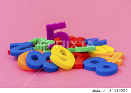 Pile of colored plastic numbers 84410596