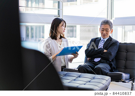 社長室で打ち合わせをする社長と秘書 84410837