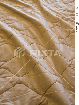 Blanket crumpled on the bed 84411688
