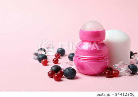Roll-on deodorant, ice cubes and berries on pink background Roll-on deodorant, ice cubes and berries on pink background 84412306