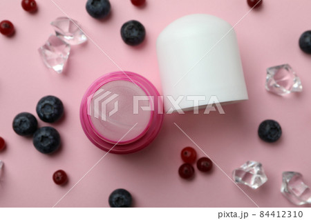 Roll-on deodorant, ice cubes and berries on pink background Roll-on deodorant, ice cubes and berries on pink background 84412310