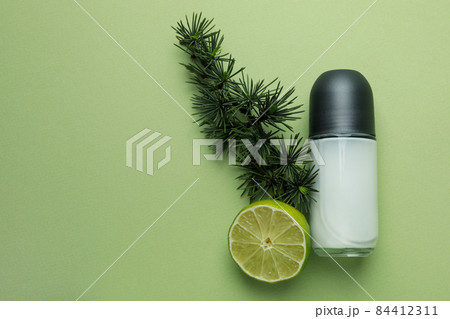 Blank deodorant, spruce twig and lime on green background Blank deodorant, spruce twig and lime on green background 84412311