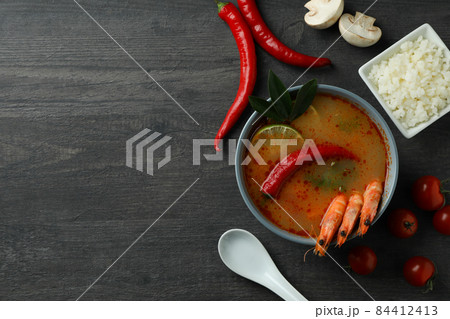 Tom yum soup and ingredients on dark wooden background Tom yum soup and ingredients on dark wooden background 84412413
