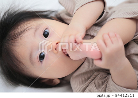 自分の足を舐める生後半年の赤ちゃん 自分の足を舐める生後半年の赤ちゃん 84412511