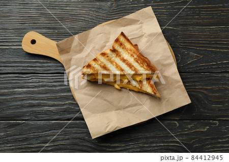 Board with grilled sandwiches on wooden table Board with grilled sandwiches on wooden table 84412945