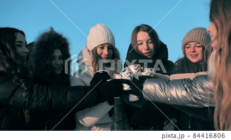 A group of girls are drinking hot tea in winter. A group of girls are drinking hot tea in winter. 84416806